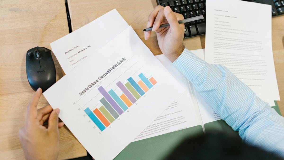 Business analyst reviewing quarterly earnings bar chart at office desk