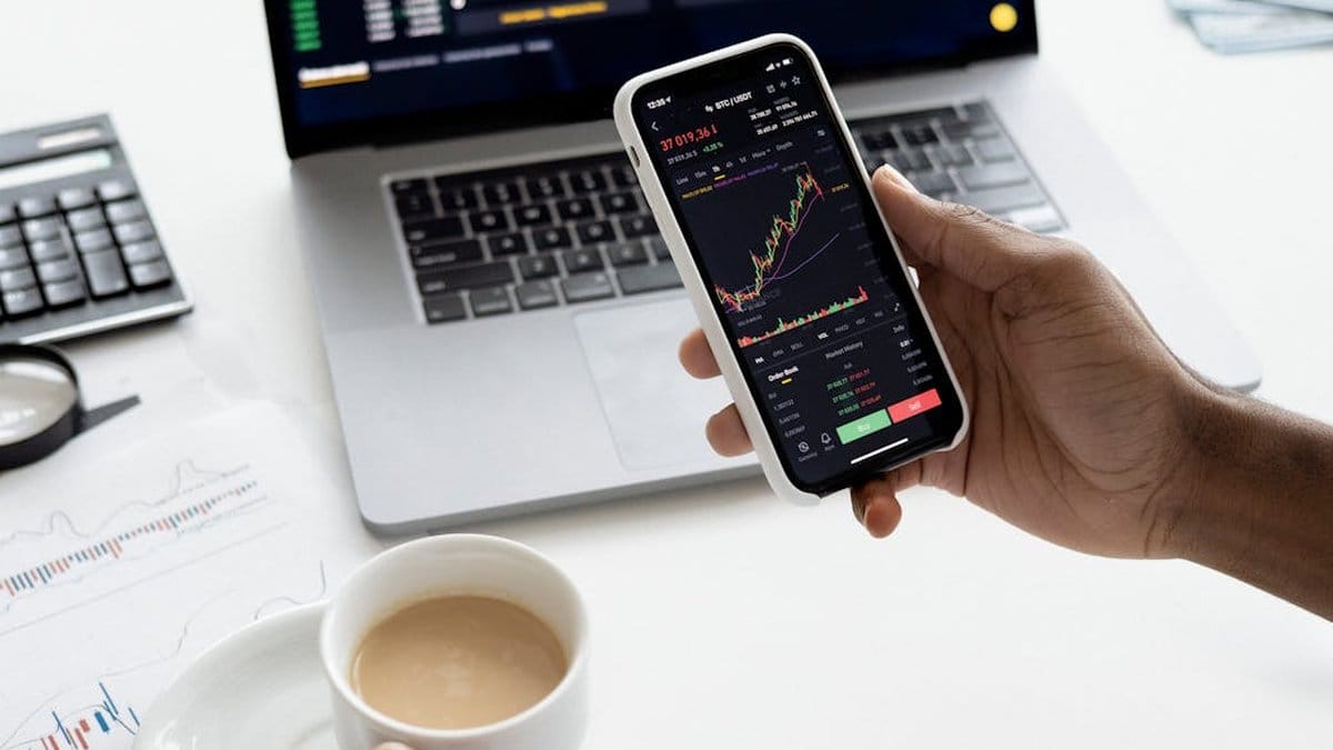 Financial analyst reviewing stock market data on multiple screens