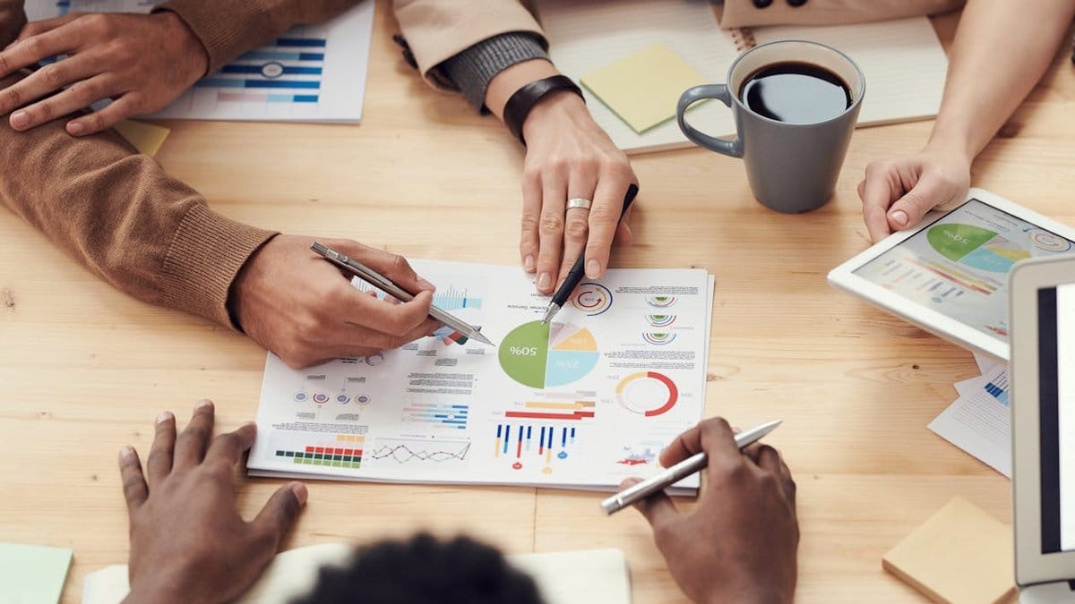 Diverse business team reviewing financial charts and sector performance data