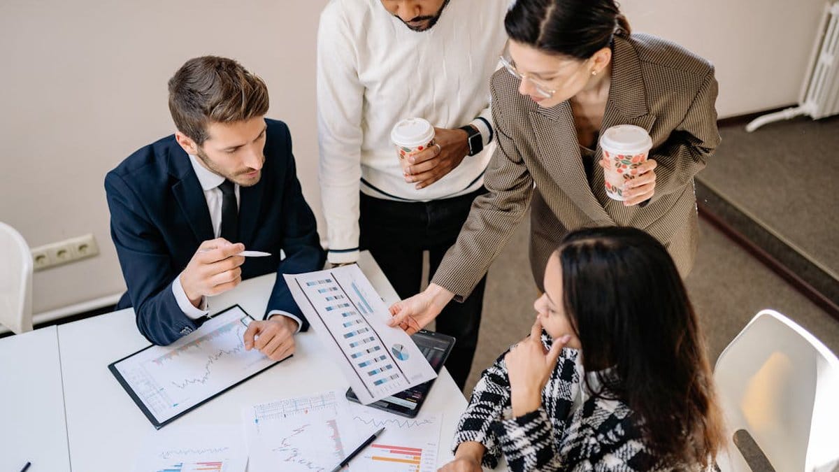 Diverse team of economists and financial professionals analyzing business graphs and economic indicators