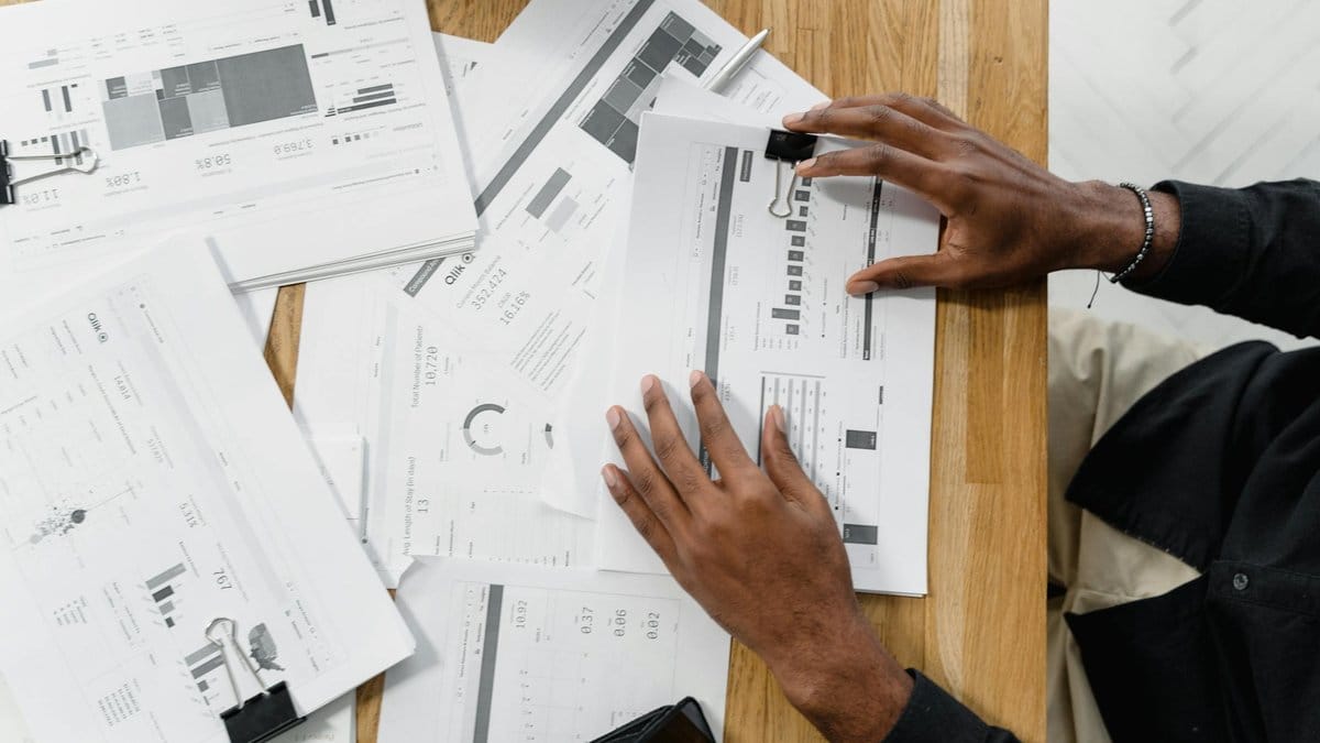 Financial analyst reviewing Q1 2026 earnings reports spread across desk