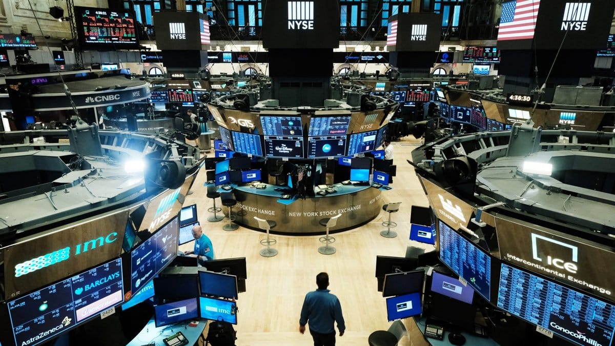 New York Stock Exchange trading floor with traders monitoring market data screens during active session