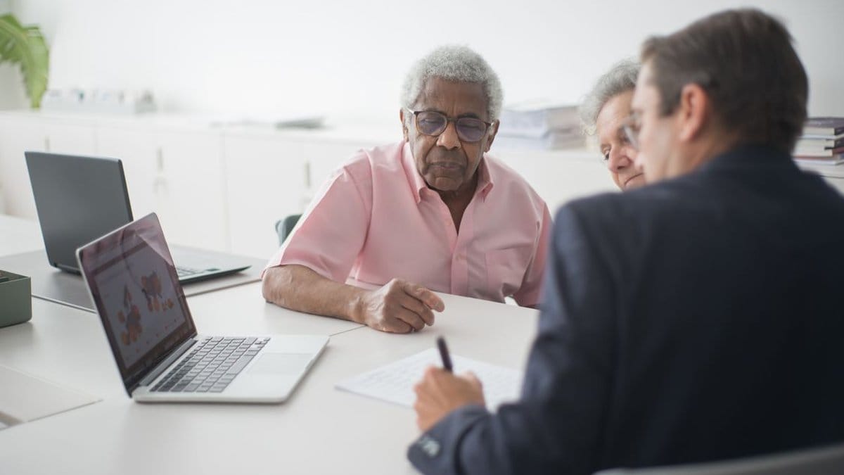Senior couple reviewing retirement contribution strategy with financial advisor