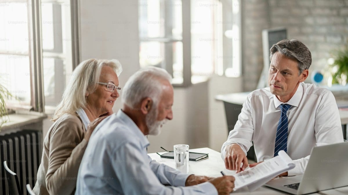 Senior couple meeting with financial advisor to review 2026 retirement contribution strategy