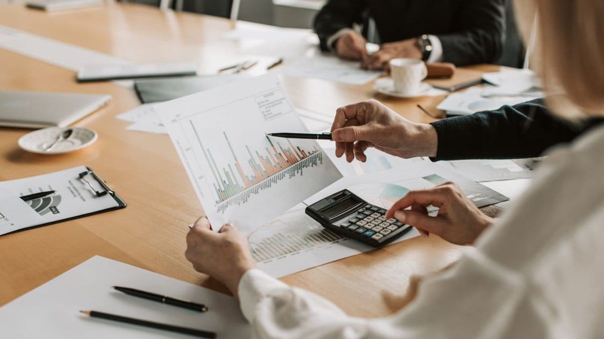 Professionals reviewing financial charts and economic reports during a business meeting