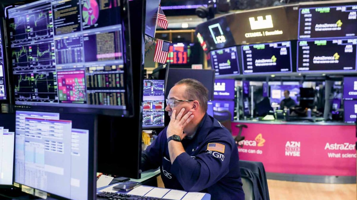 NYSE trader monitors market data amid inflation and Iran tensions