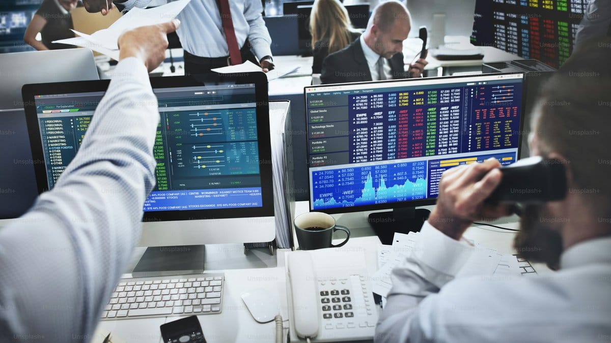 Financial traders monitoring stock market data on multiple screens
