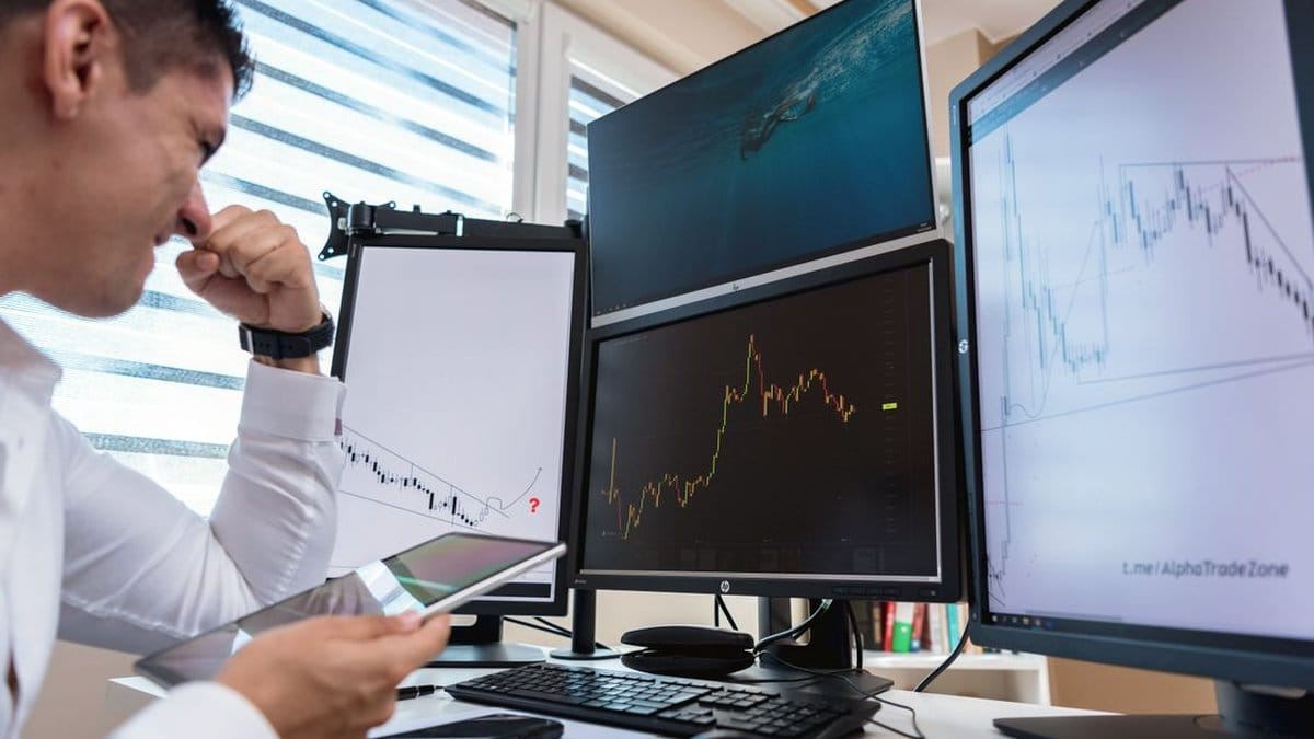 Financial analyst reviewing precious metals market data on multiple trading screens