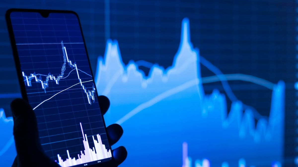 Investor monitors stock market charts on smartphone as Bank of America forecasts three Fed rate hikes in 2026