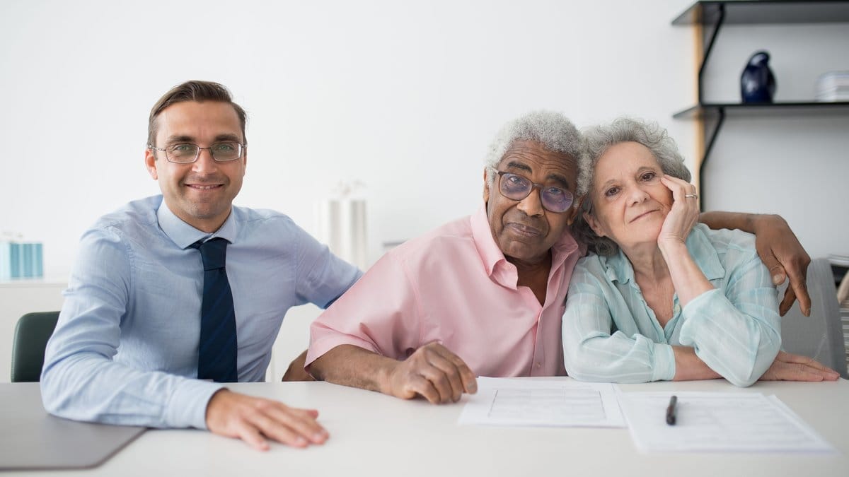 A diverse retired couple meeting with a financial professional to review their investment plan