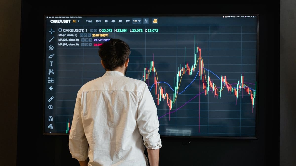 Analyst reviewing cryptocurrency market charts on a large trading screen