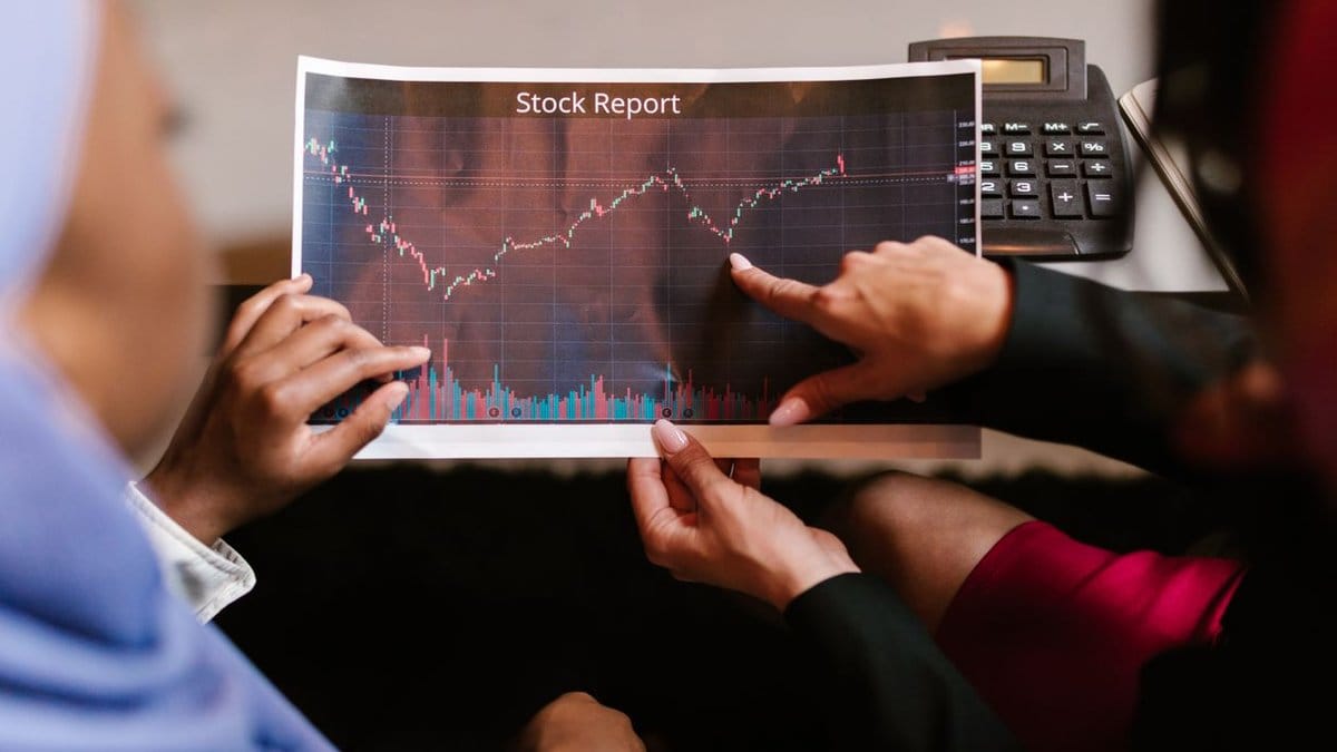 Two financial professionals analyzing stock report charts during earnings season review