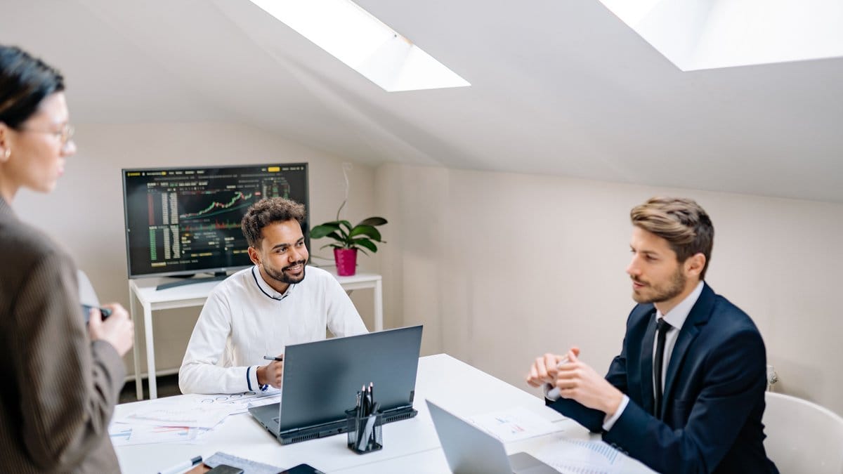 Diversified group of financial professionals monitoring market data in a modern trading floor