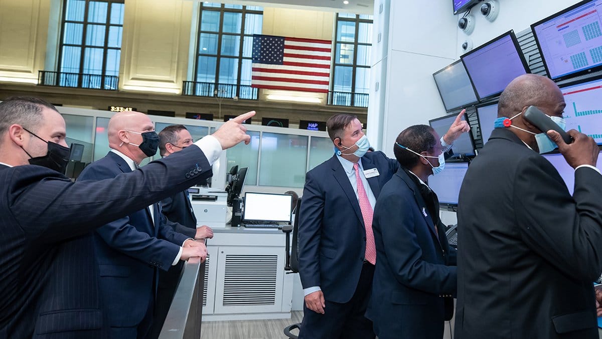 Traders monitor financial data on multiple screens at the New York Stock Exchange as the Dow Jones Industrial Average reaches a record high