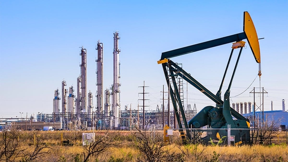 Oil pump jack and refinery complex representing energy sector volatility amid Iran-US tensions