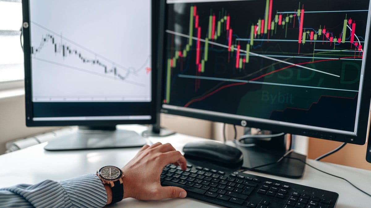 A market participant monitors stock charts ahead of a busy week for inflation data and earnings