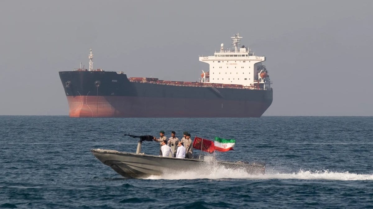 Iranian Revolutionary Guard speedboat passes near an oil tanker in the Strait of Hormuz as US-Iran tensions escalate pushing Brent crude above $96