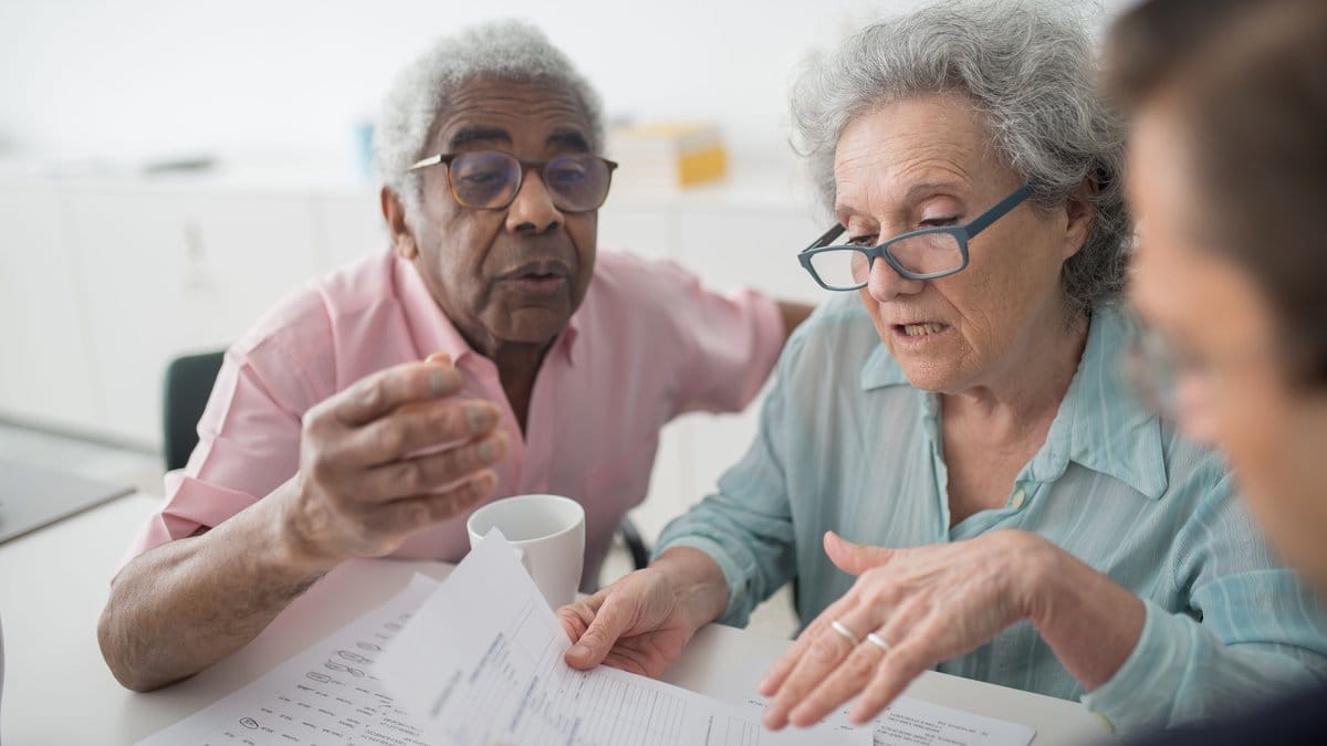 Older couple reviewing retirement documents with an advisor