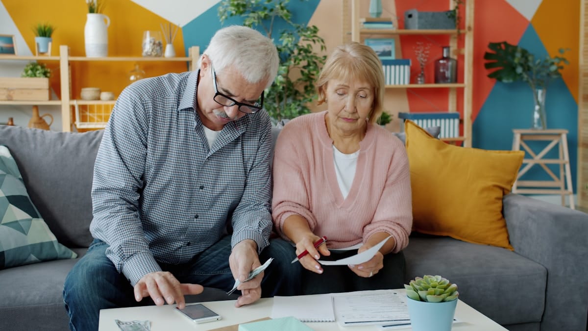 Senior couple reviewing retirement documents and financial statements at home