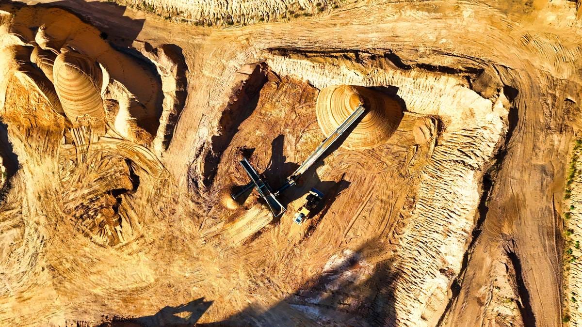 Aerial view of an open-pit mining operation, representing precious metals extraction industry