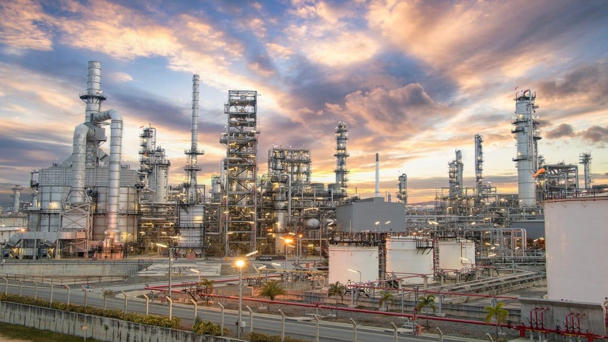 Aerial view of an oil refinery at sunset, representing the global energy market and crude oil production