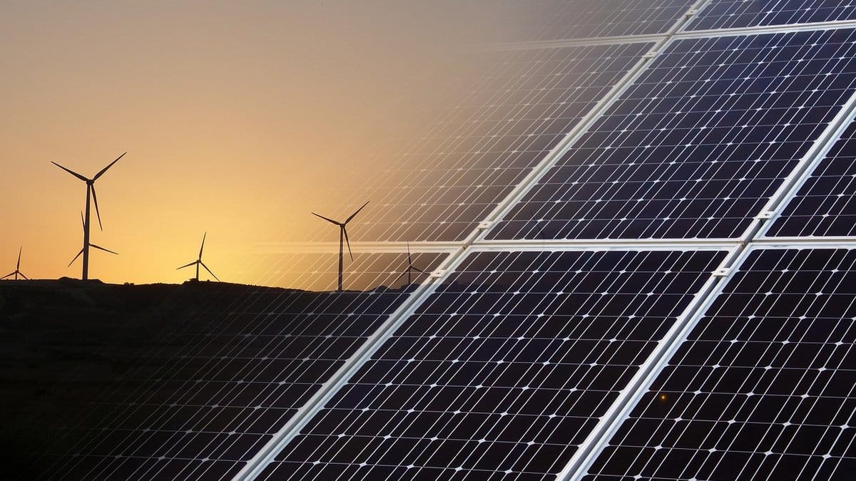 Solar panels and wind turbines at a renewable energy facility