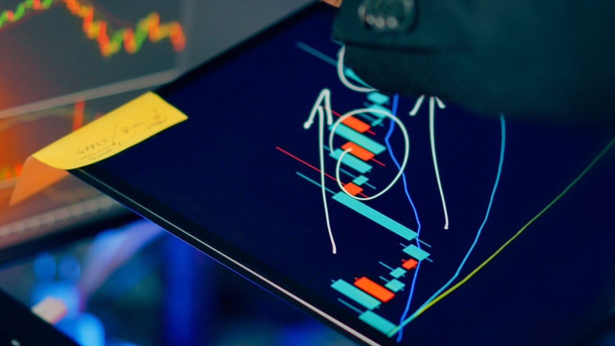Financial analyst reviewing stock market charts and trading data on tablet and laptop screens for weekly market preview