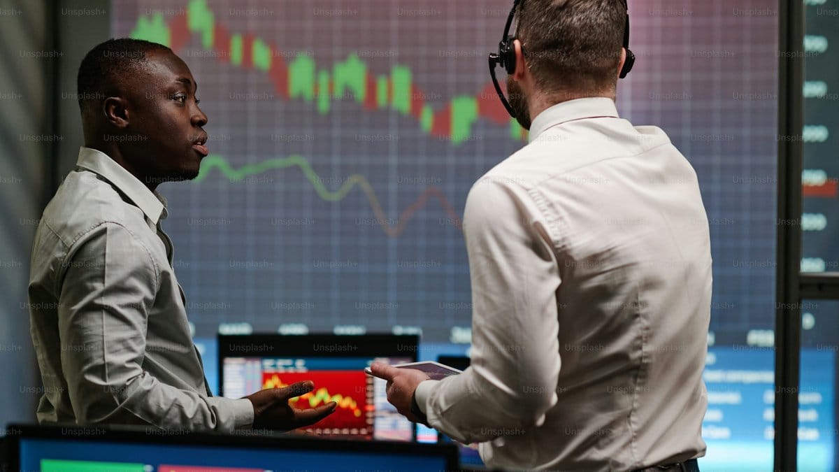 Financial market analysts reviewing trading data and charts in a modern trading room