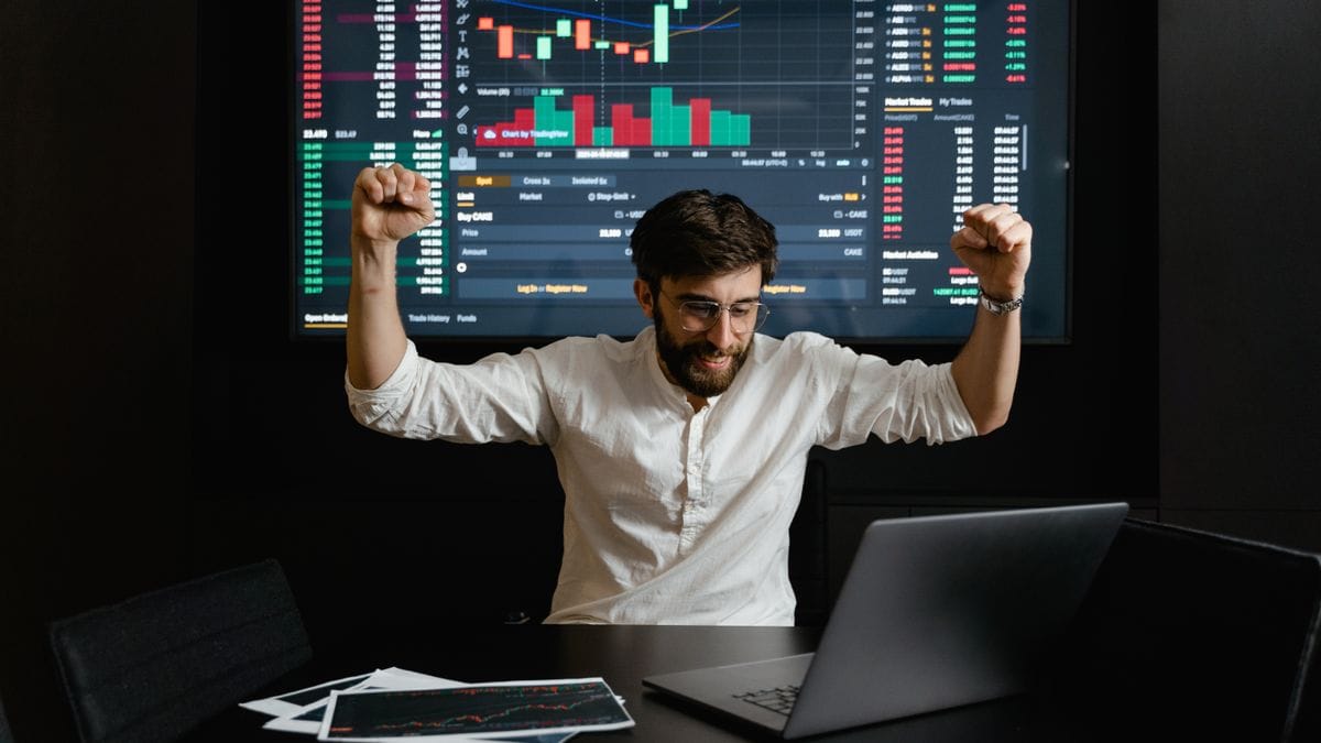 Financial trader monitoring precious metals market data on multiple screens