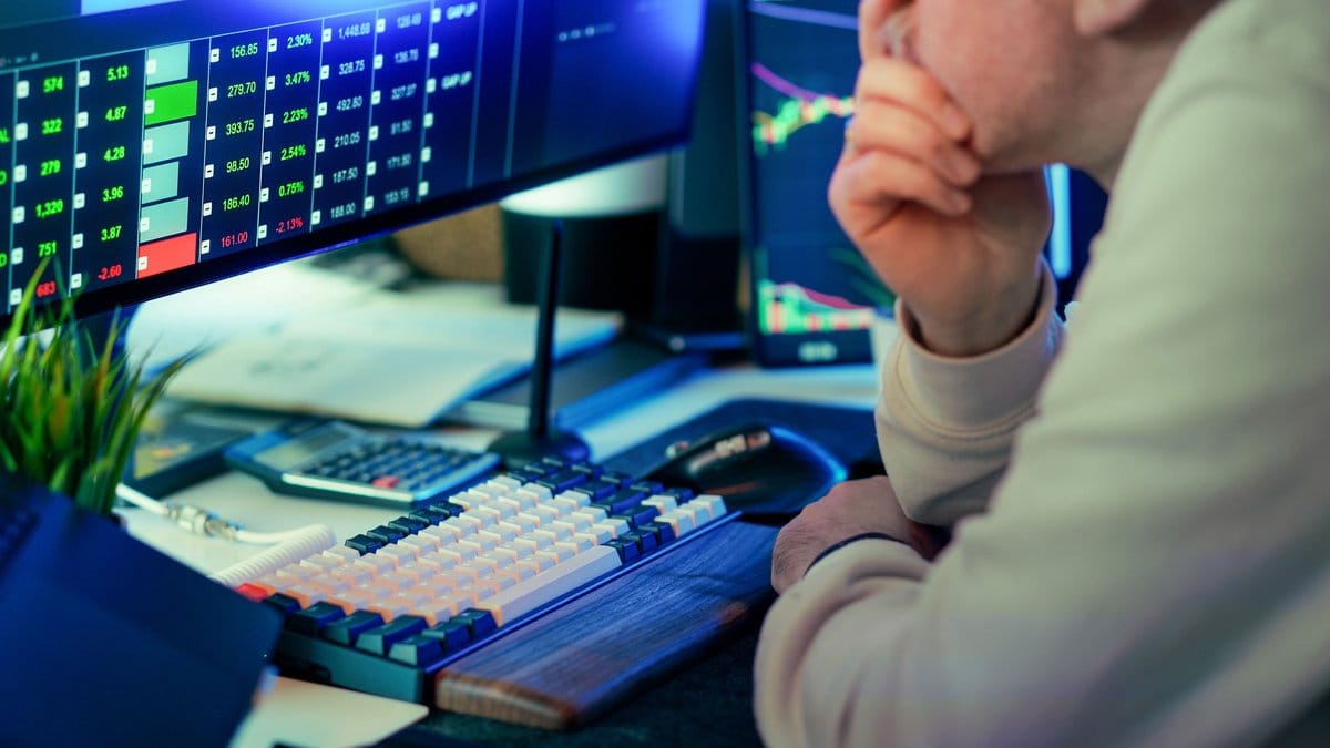 Financial market analyst monitoring trading screens during heightened market volatility