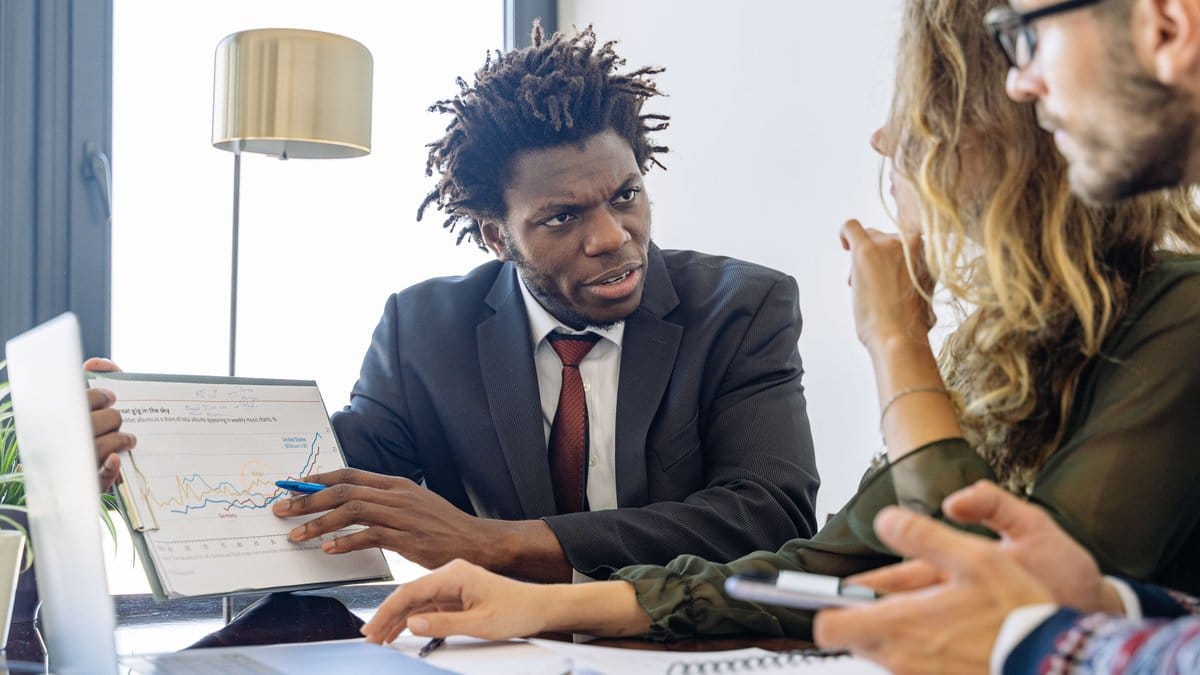 Financial advisor discussing market performance with clients in an office