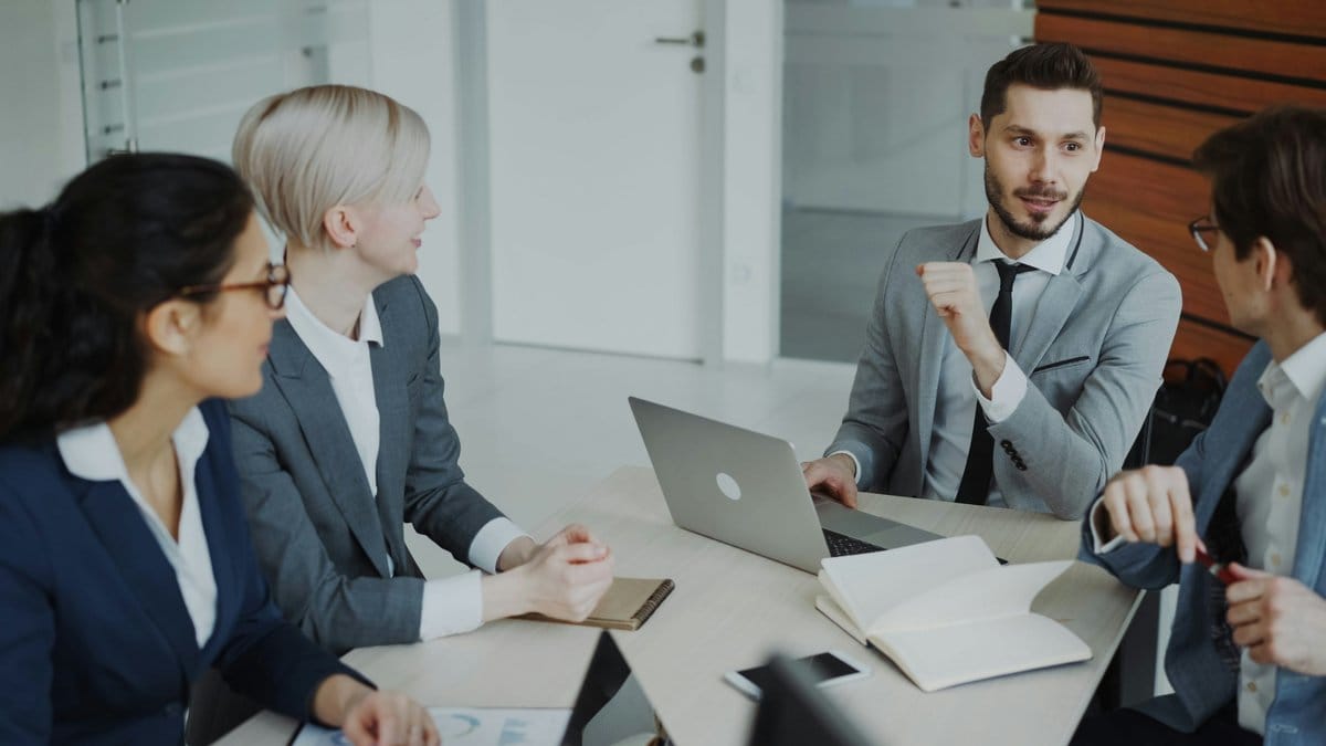 Financial professionals discussing market conditions in a modern office meeting.