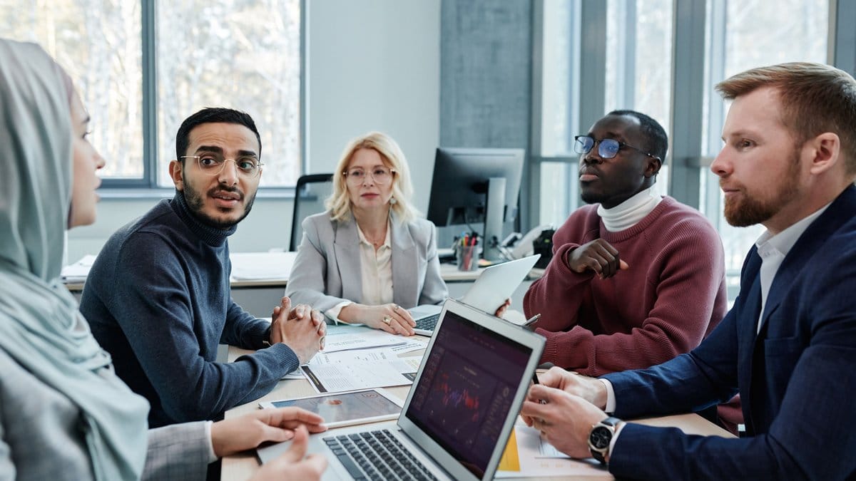 Diverse financial professionals discussing market strategy around a conference table