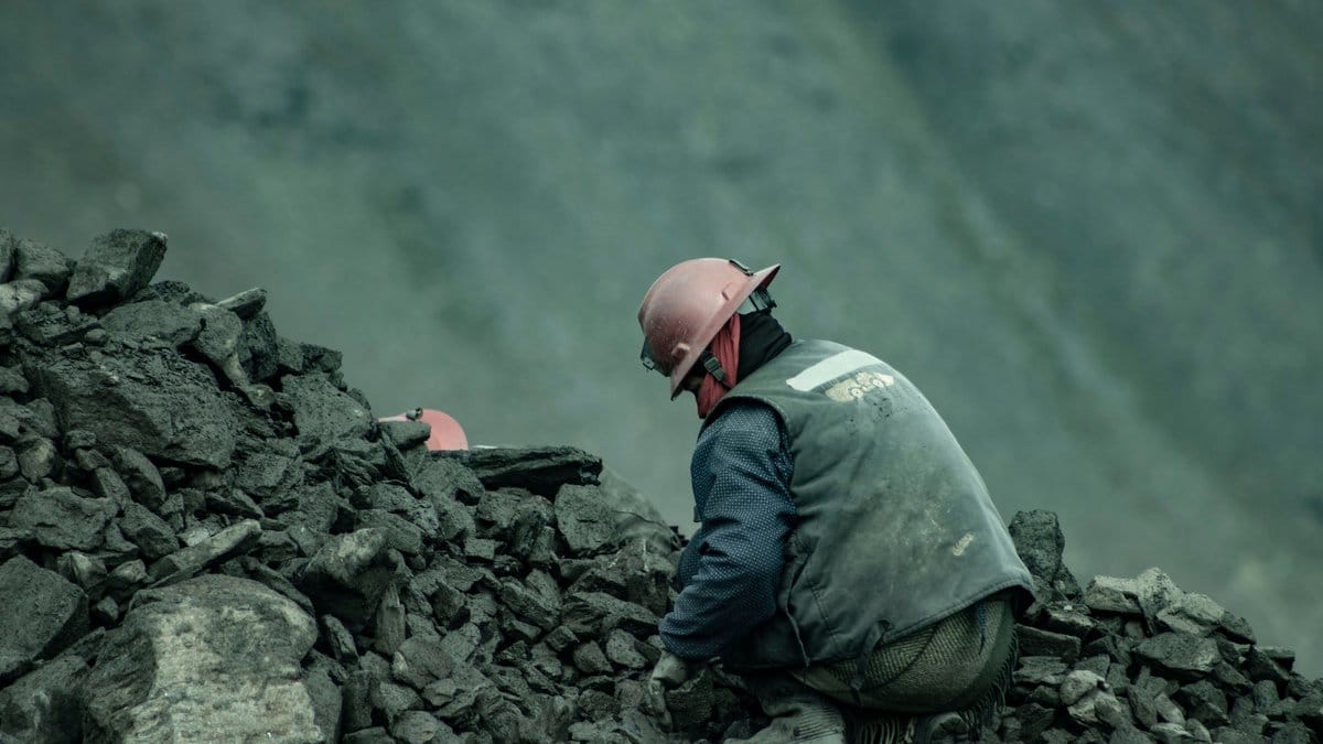 Miner working with ore at a precious metals mining operation