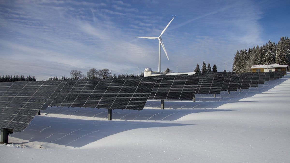 Solar panels and a wind turbine at a renewable energy facility