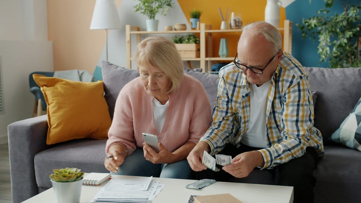 Older couple reviewing household bills and retirement budget at home