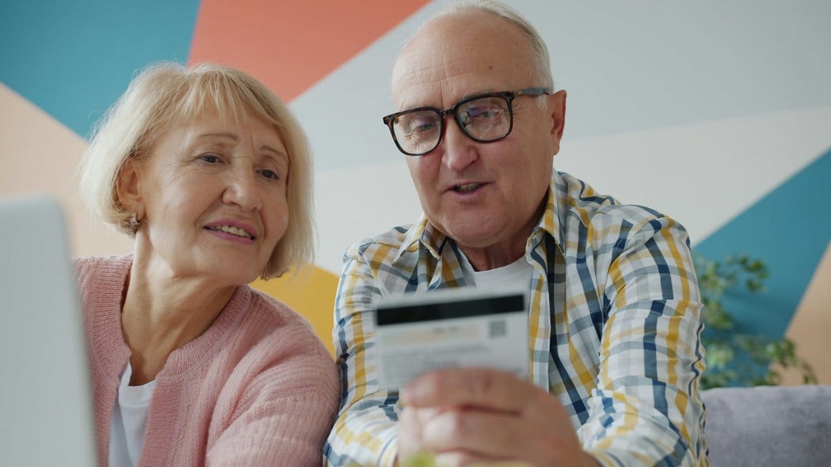 Older couple reviewing a financial account together on a laptop