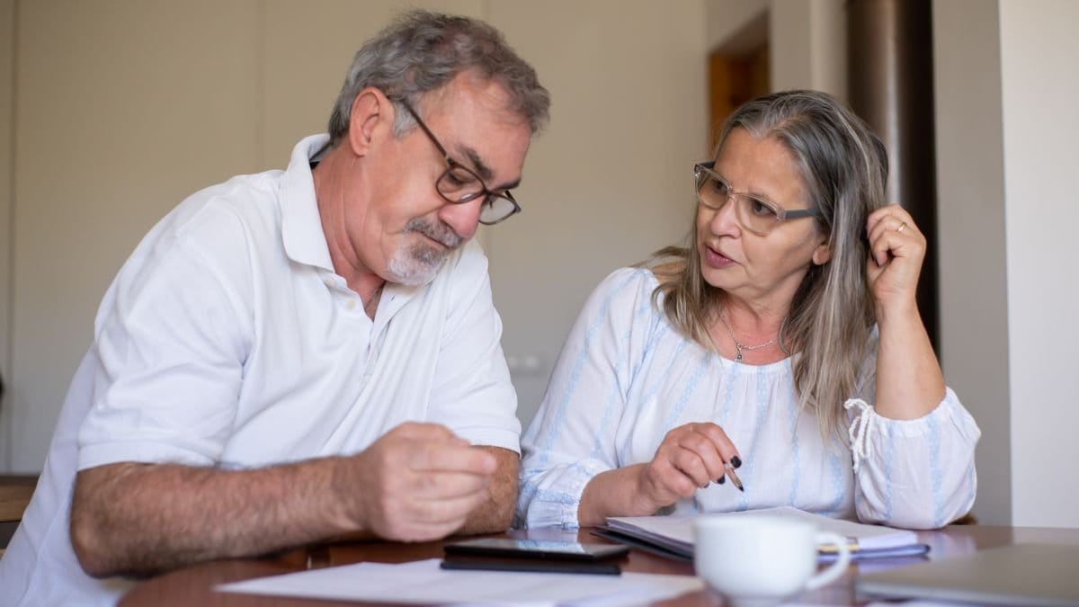 Older couple reviewing retirement documents and household finances at home