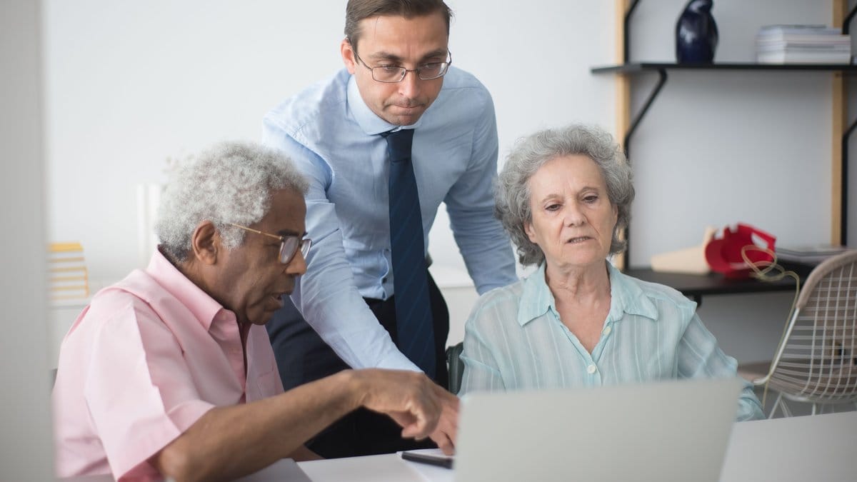 Financial advisor showing documents to an older couple reviewing retirement income choices