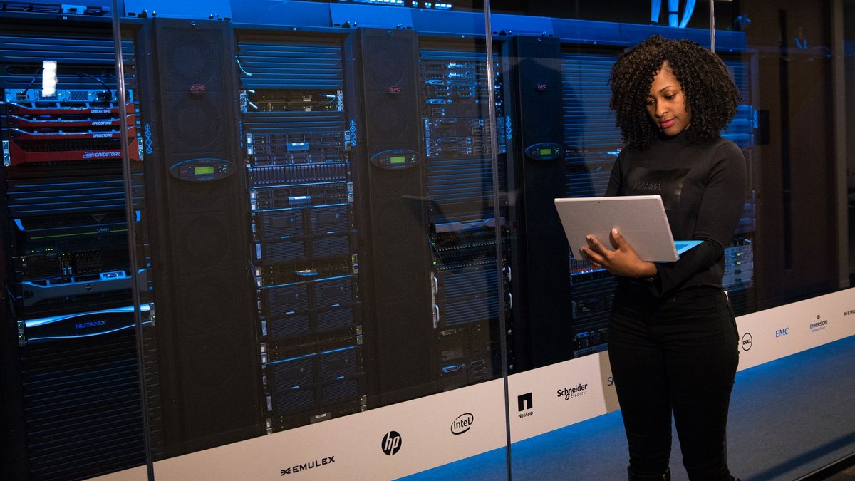 Engineer inspecting server infrastructure with a laptop, illustrating digital-asset network operations