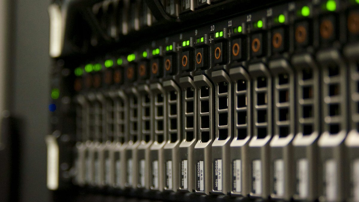Server racks with green status lights illustrating AI data center infrastructure and technology earnings
