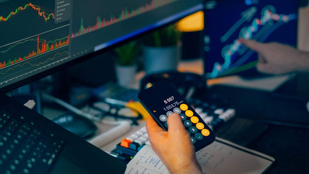 Trader reviewing market charts and financial calculations for a daily market report