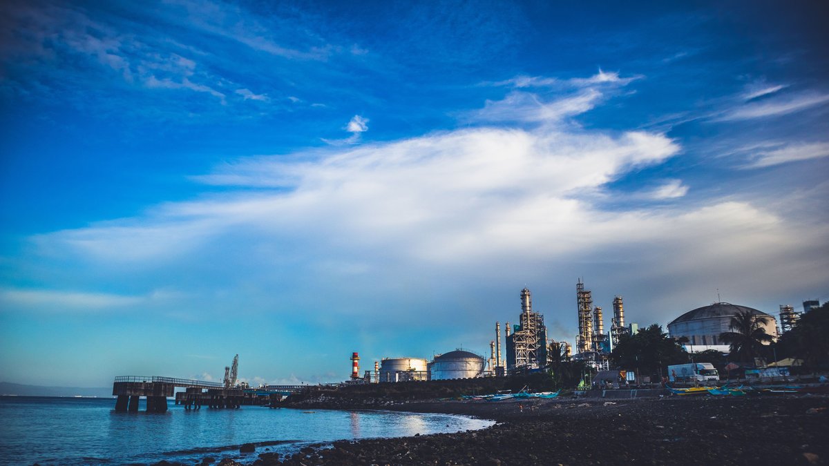 Daytime view of a modern oil refinery with processing towers and storage infrastructure