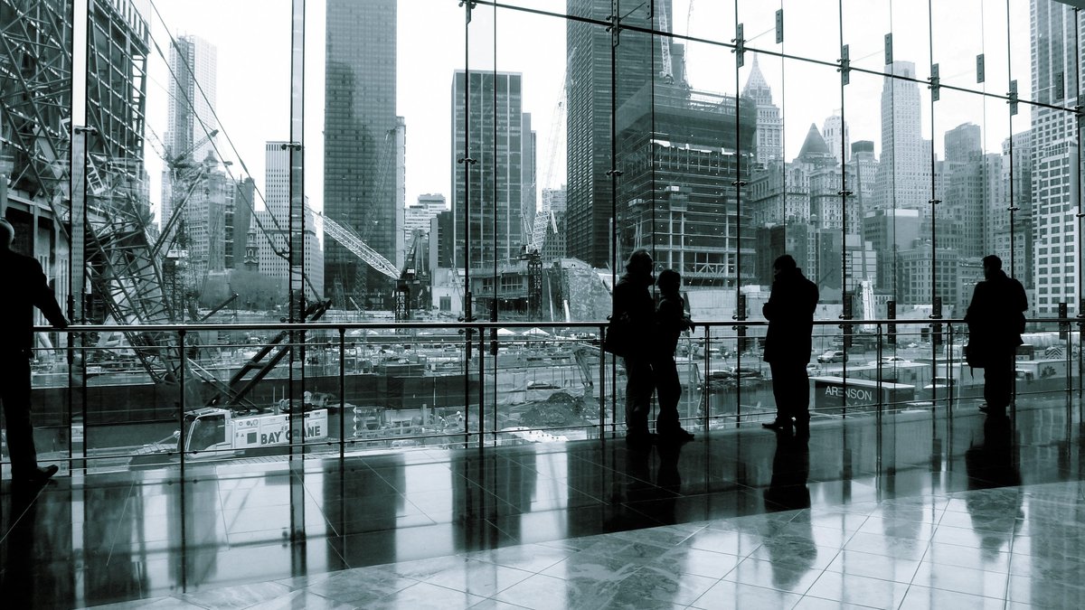 Financial-district professionals viewed through a modern office window