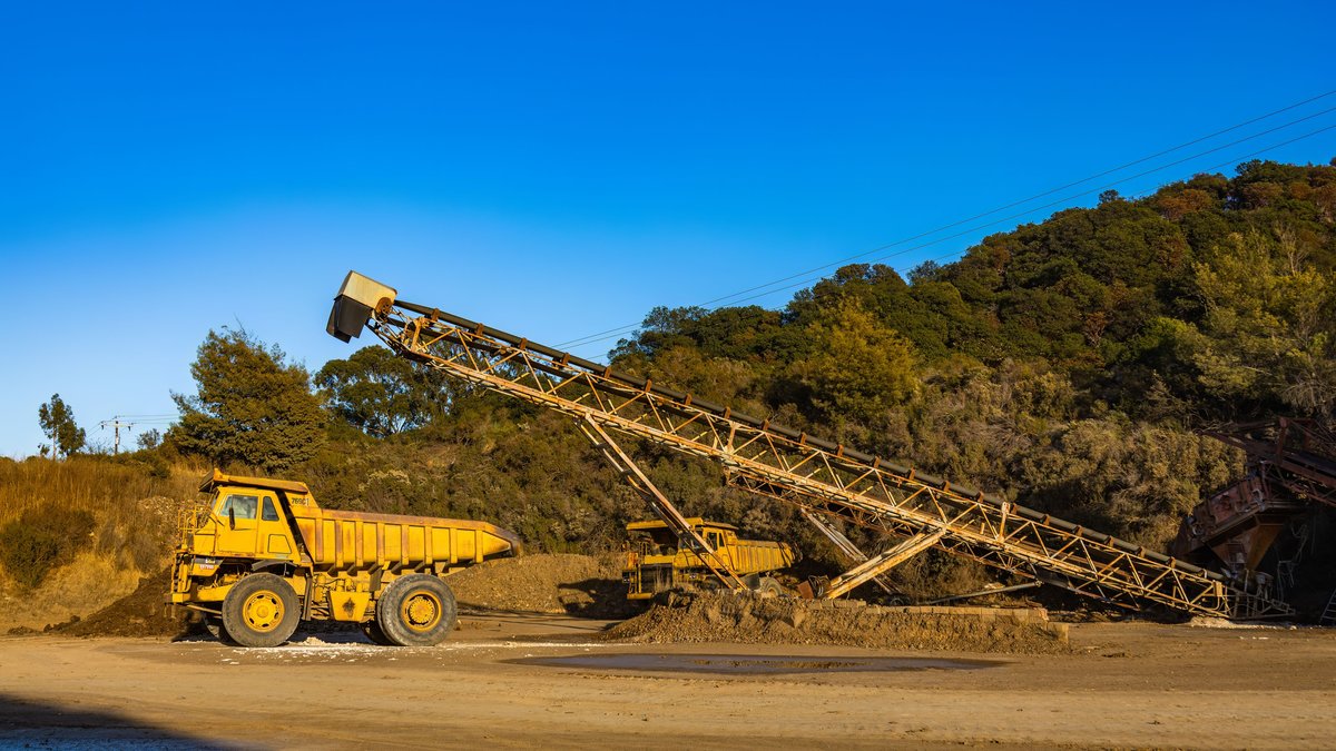 Mining haul trucks and conveyor equipment illustrating the operating costs and infrastructure behind the precious metals mining sector