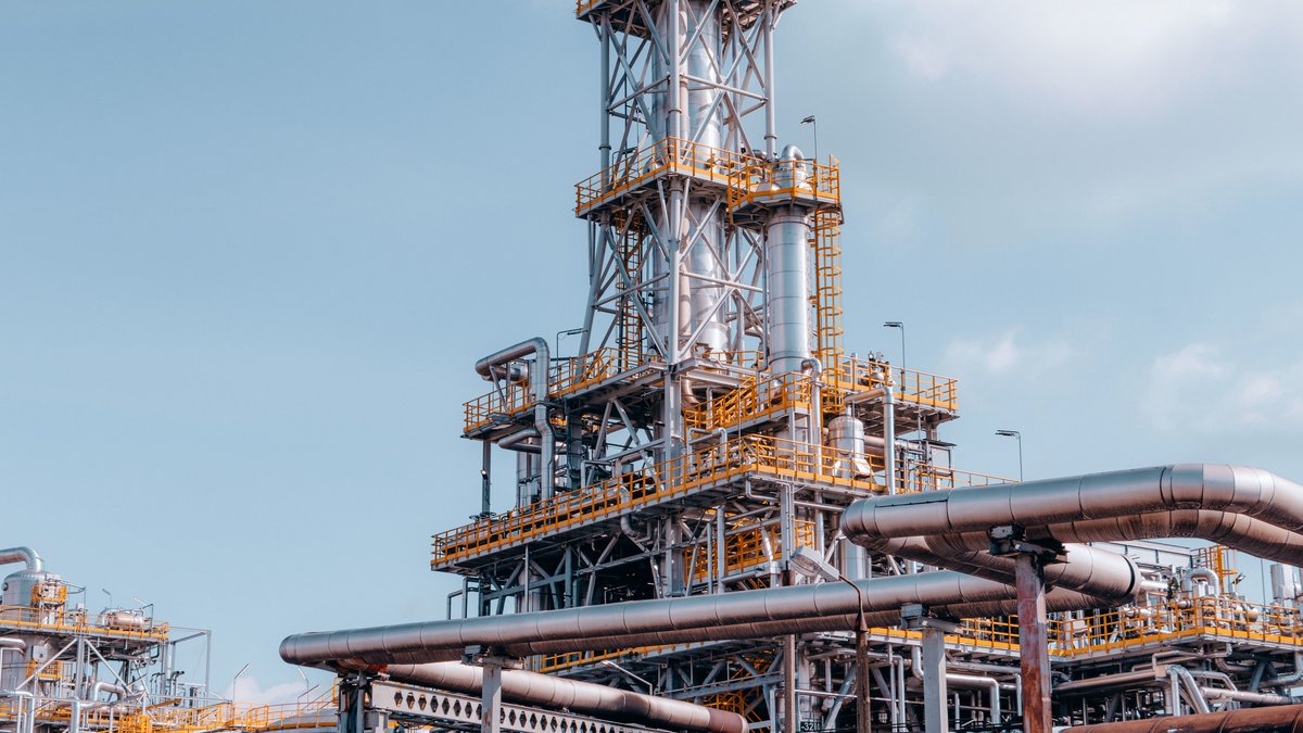 Oil refinery tower and pipelines in Trzebinia, Poland, illustrating energy-sector infrastructure
