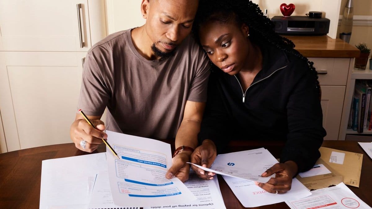 Couple organizing financial paperwork and retirement savings documents at a table